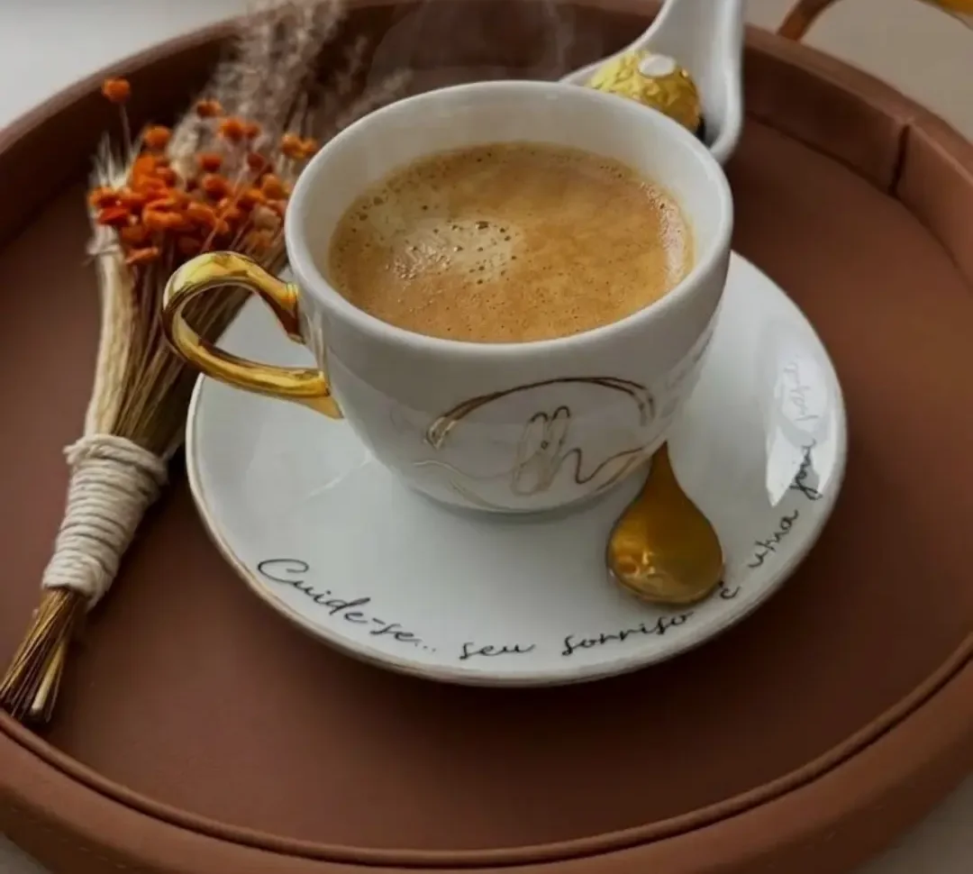 Xícara de café com o monograma LH sobre bandeja, no consultório da Dra. Letícia